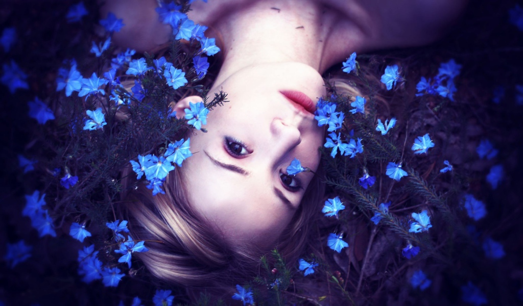 Девушка среди маленьких голубых цветов
