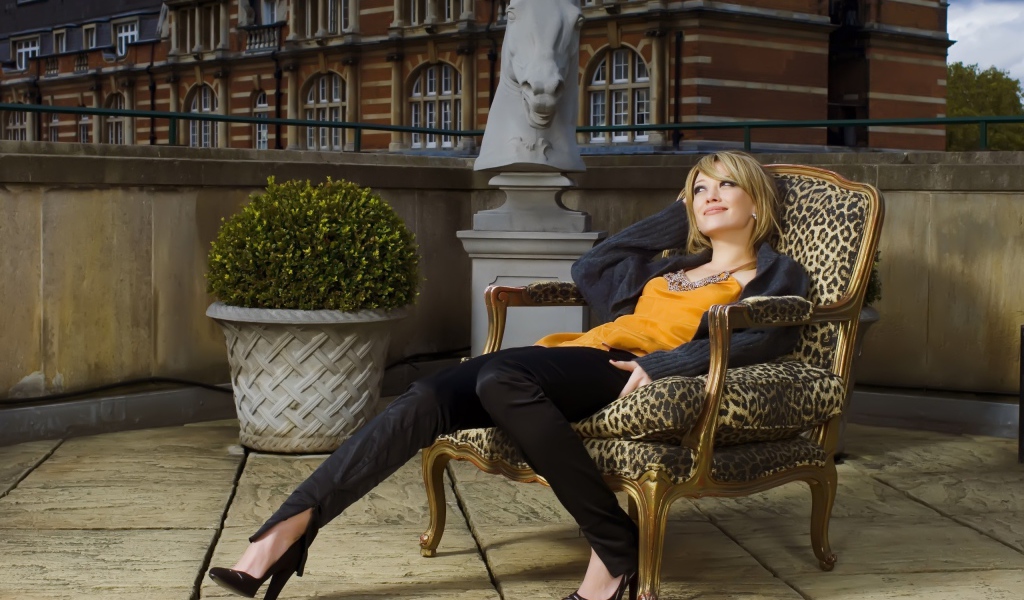 Девушка замечталась сидя на кресле