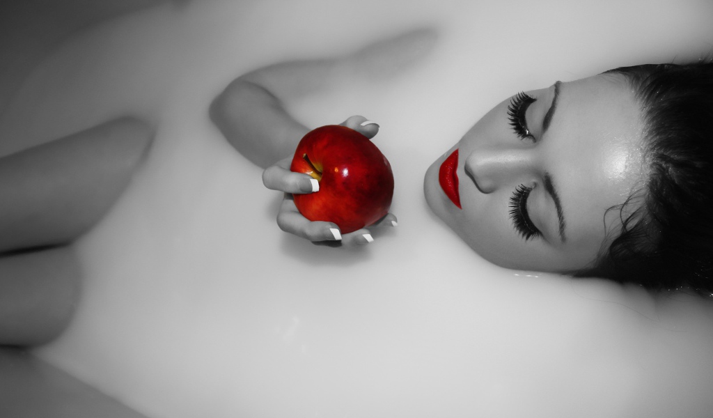 Девушка ест яблоко лежа в ванной