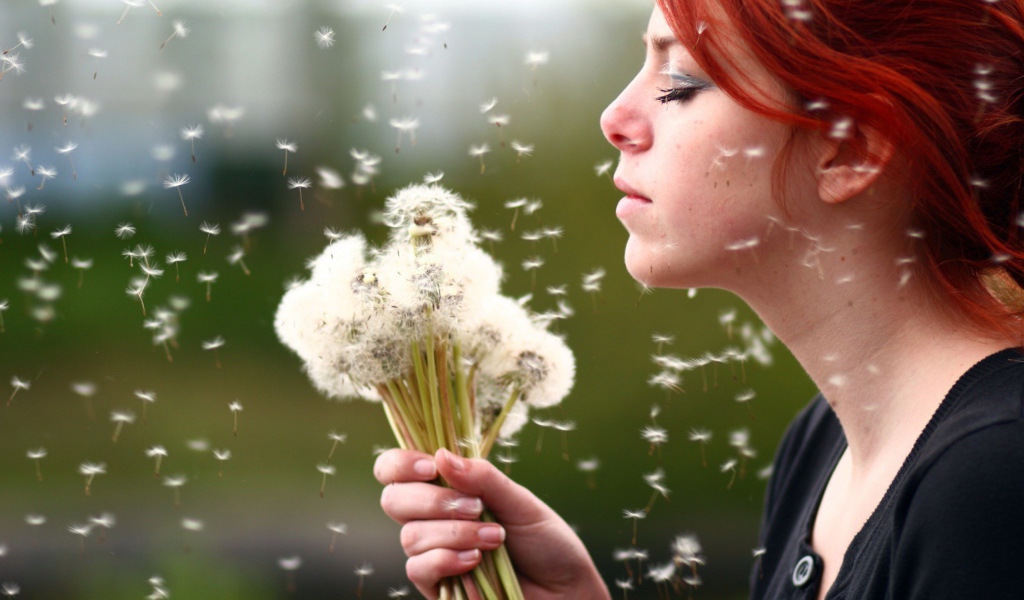 Девушка держит в руках букет одуванчиков