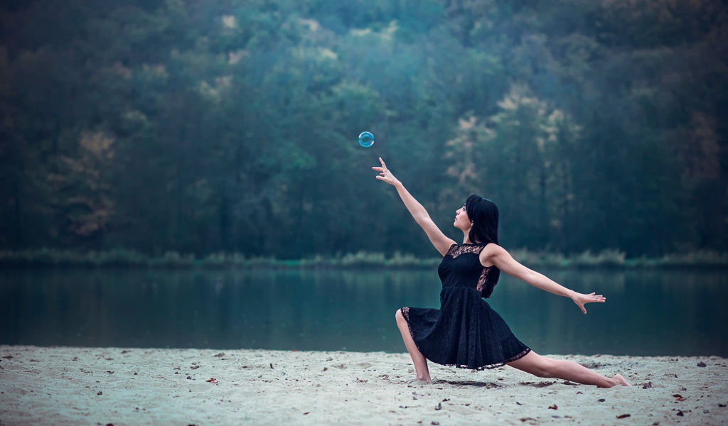 Девушка в черном платье и мыльный пузырь