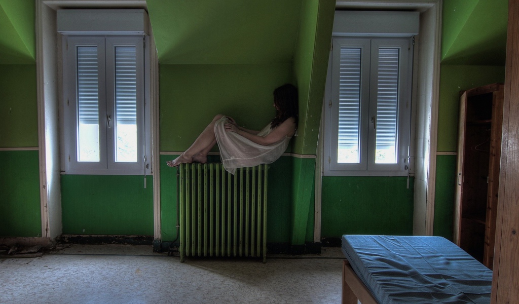 Девушка в ночной рубашке сидит на батарее