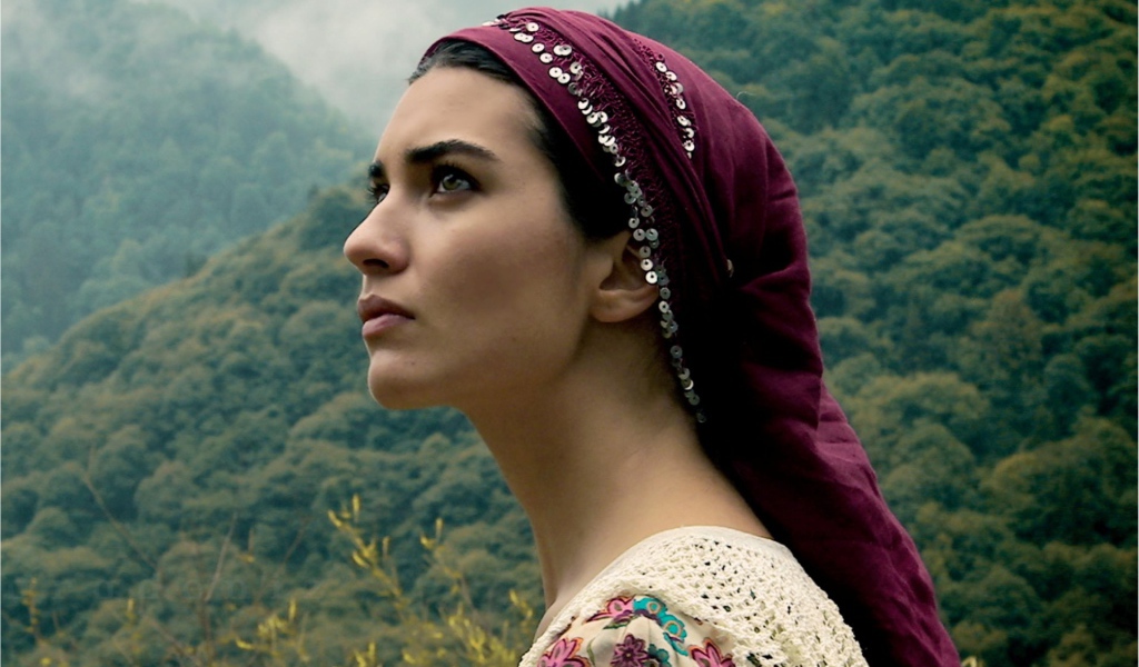 Девушка в красной косынке на фоне горного леса