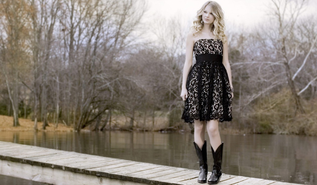 Девушка в черном платье и кожаных сапогах