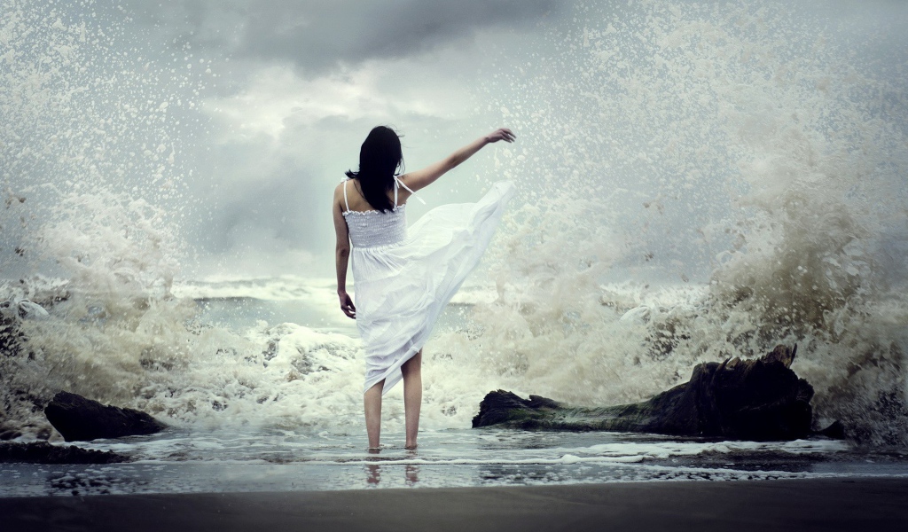 Девушка в белом платье среди брызг прибоя