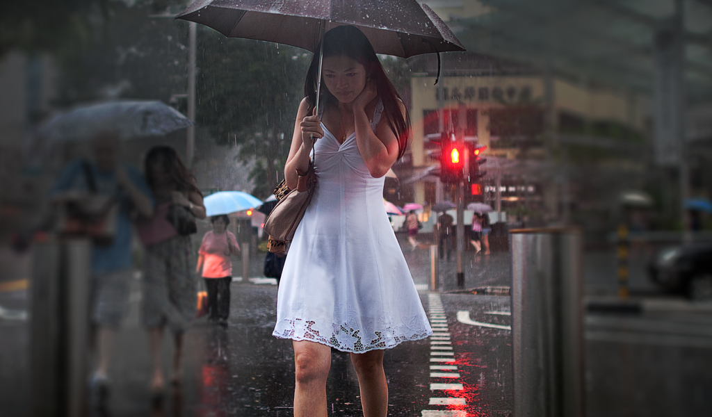 Девушка в белом платье идет под зонтом