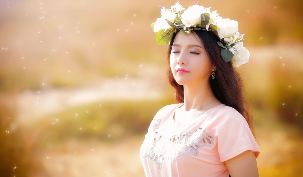 Девушка в белом венке прикрыла глаза