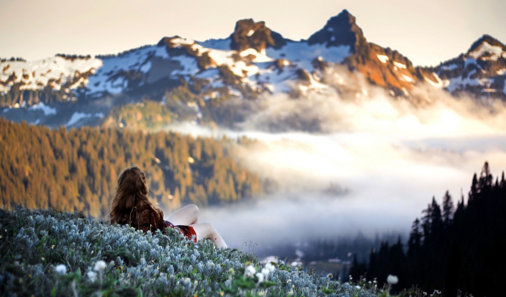 Девушка лежит и смотрит на горы