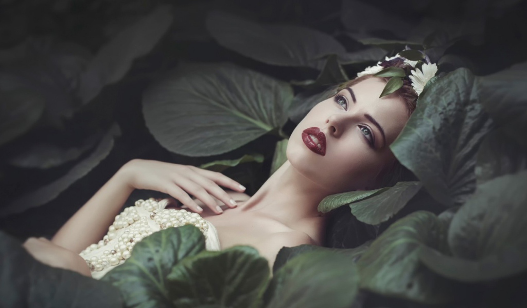 Девушка лежит в больших листьях