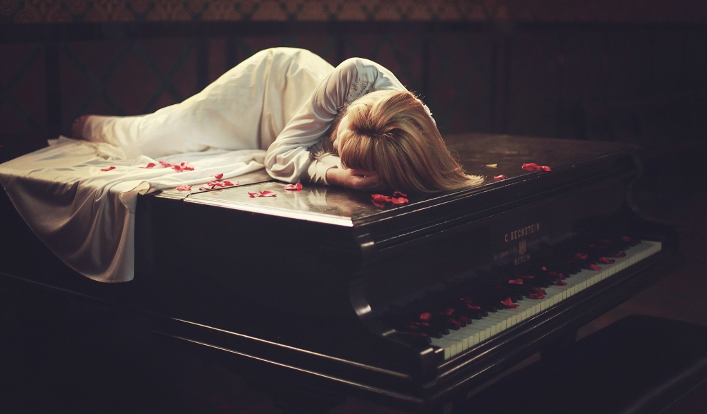 Девушка лежит на рояле