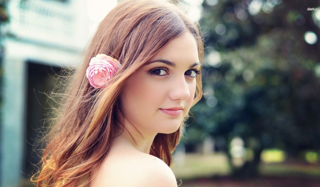 Девушка модель с розовым цветком в волосах