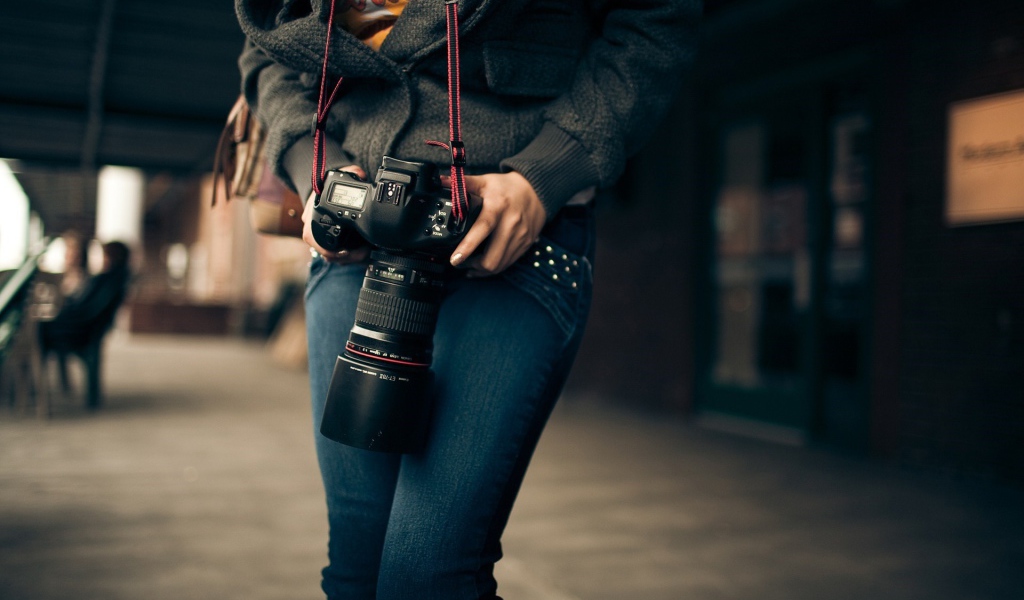 Девушка фотограф с профессиональным фотоаппаратом Canon