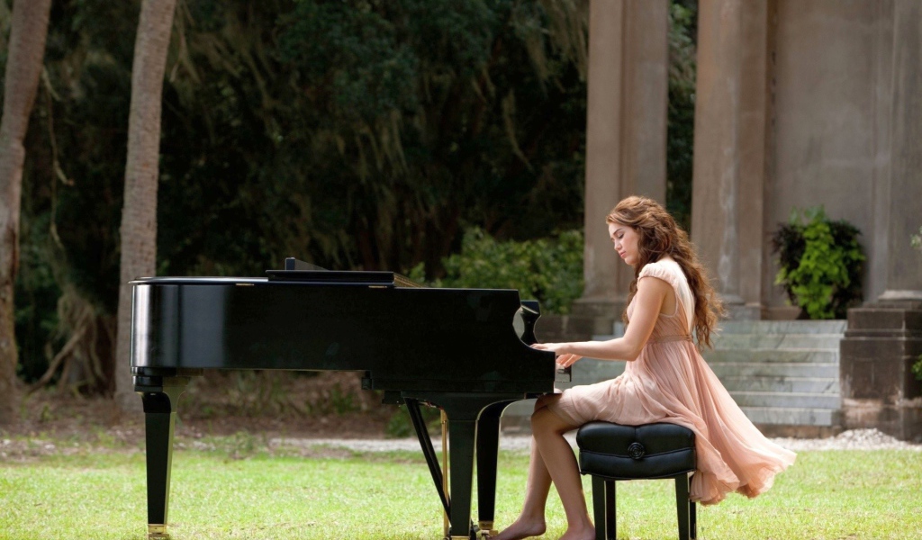 Девушка сидит за роялем на улице