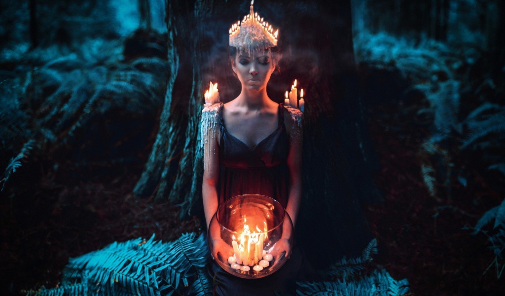 Девушка в окружении свечей в лесу