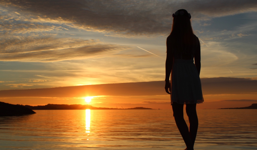 Девушка смотрит на закат в Норвегии
