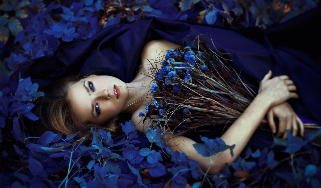 Девушка с букетом среди синих цветов
