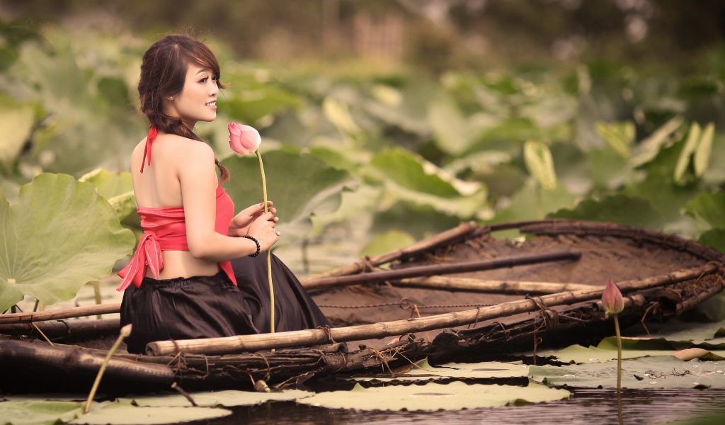 Девушка с цветком сидит в лодке