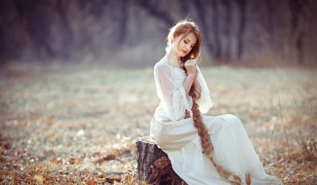 Девушка с косой сидит на пеньке