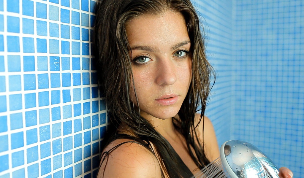 Зеленоглазая брюнетка стоит в душе