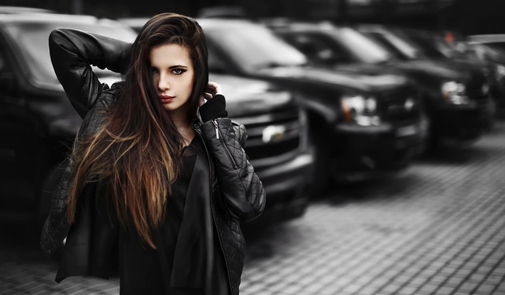 Черноволосая девушка на фоне черных автомобилей