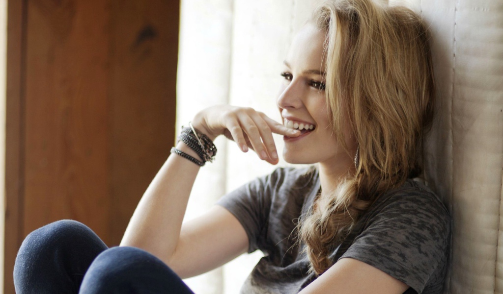 Смеющаяся блондинка приложила палец к губам