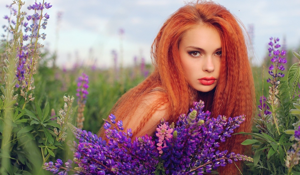 Длинноволосая рыжая девушка в поле лаванды