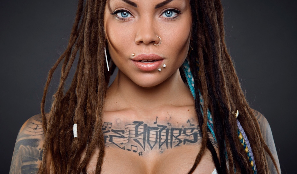 Музыкальное тату на груди у девушки с кольцом в носу