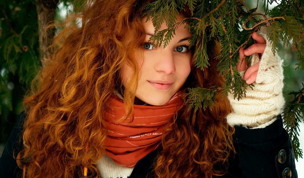 Рыжая девушка под ветками ели