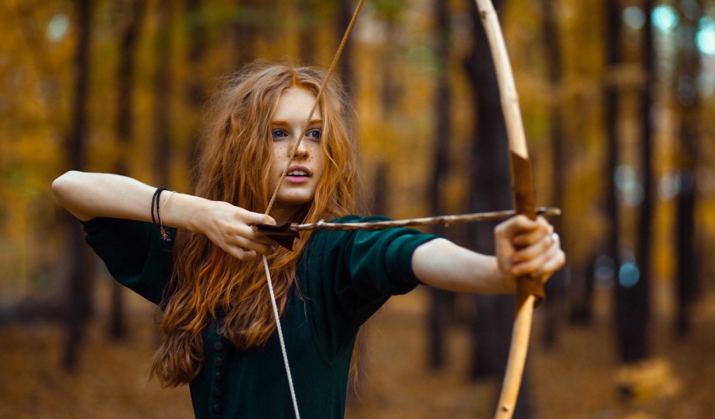 Рыжая девушка целится из лука