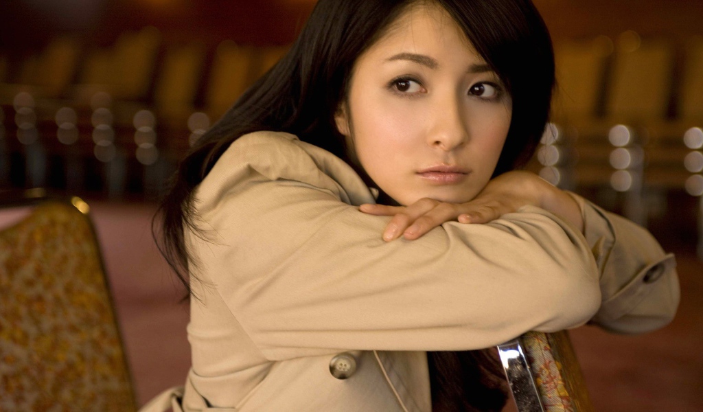Грустная азиатская девушка в коричневом плаще