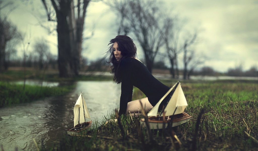 Девушка пускает кораблики по ручью