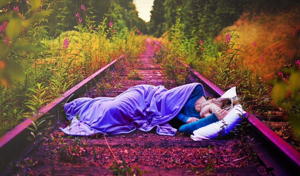 Девушка спит на заброшенных рельсах