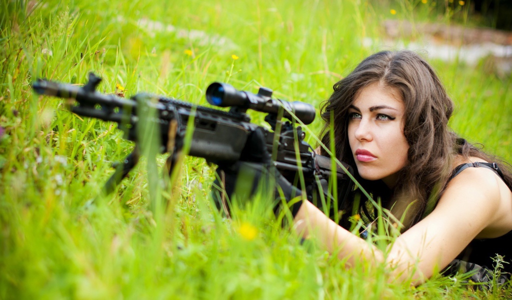 Девушка снайпер залегла в траве