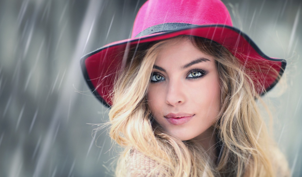 Блондинка в розовой шляпе под дождем