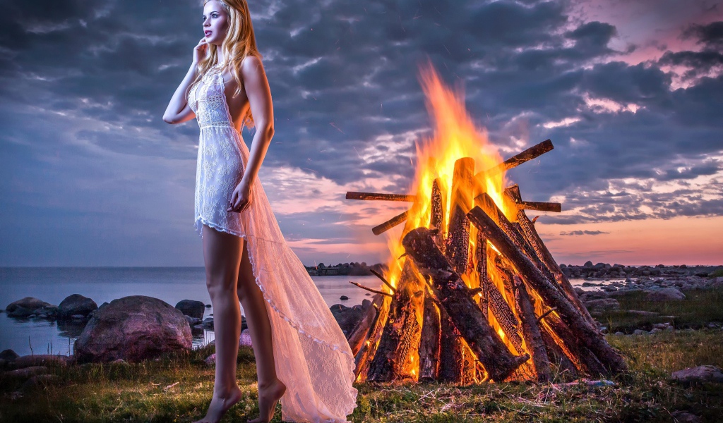 Девушка у костра на берегу океана