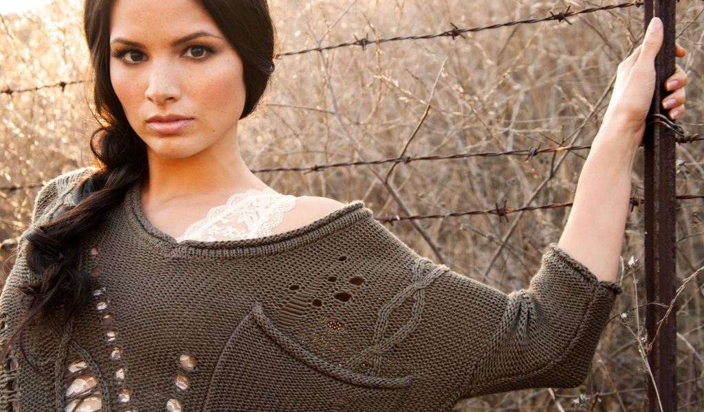 Девушка у забора из колючей проволоки