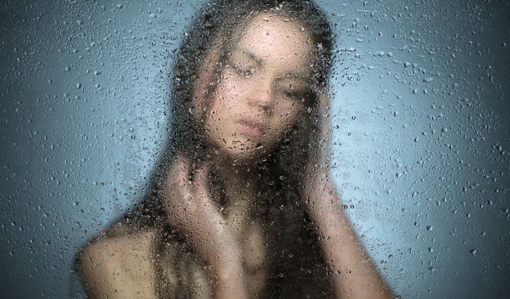 Девушка позади мокрого стекла
