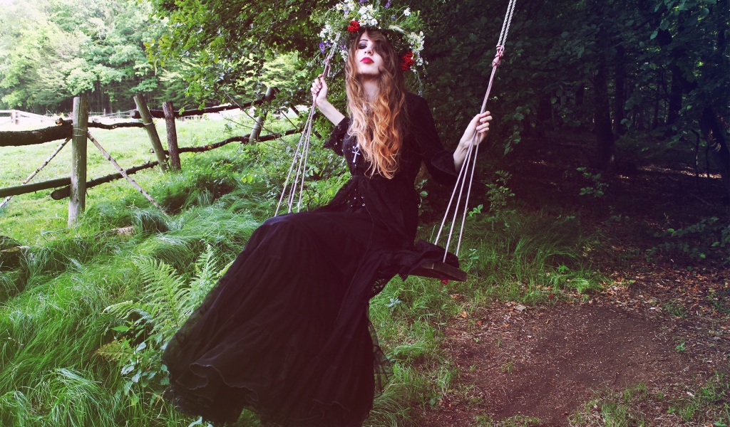 Девушка в черном платье на качели