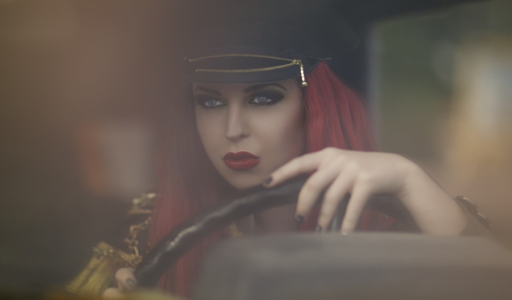 Девушка в фуражке за рулем