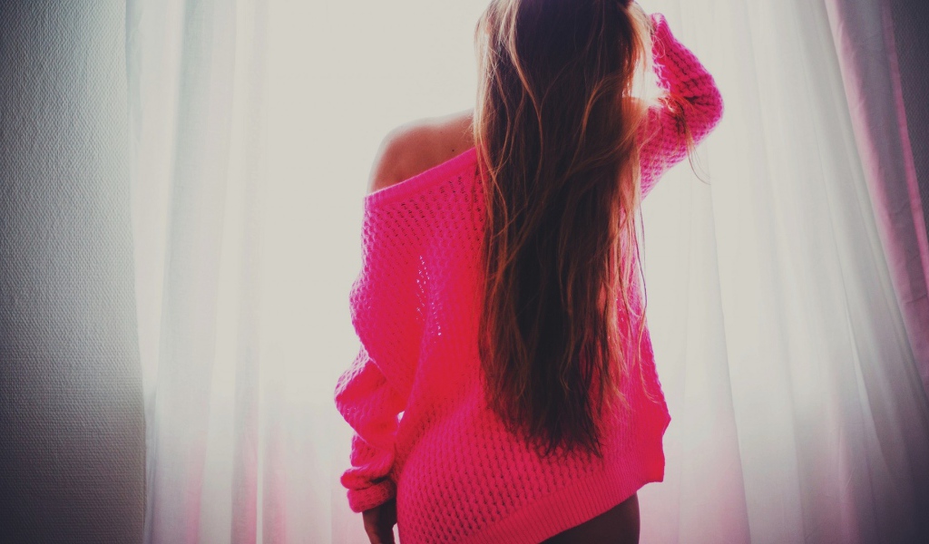 Девушка в розовой кофте стоит спиной