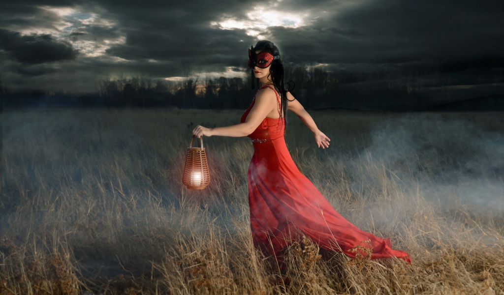 Девушка в красном платье с фонарем в поле
