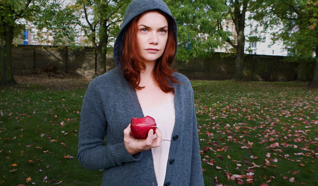 Девушка в капюшоне с яблоком