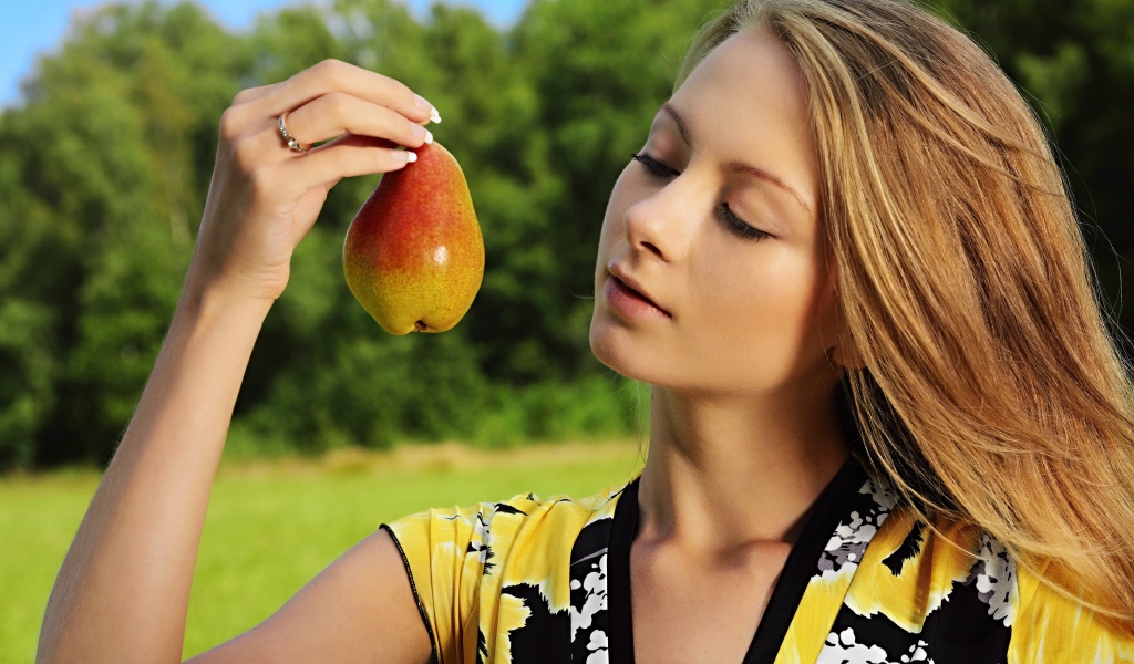 Девушка смотрит на грушу