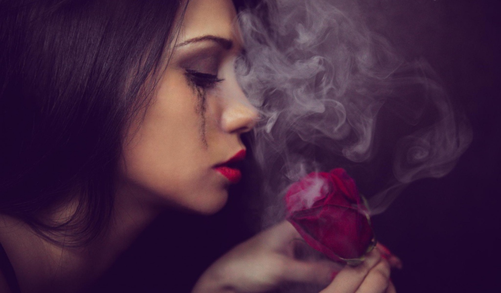 Девушка смотрит на дымящуюся розу