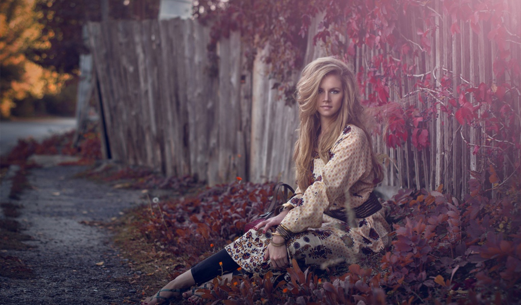 Девушка присела у забора