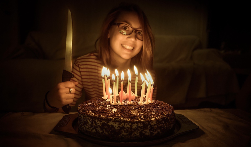 Девушка с ножом у праздничного торта