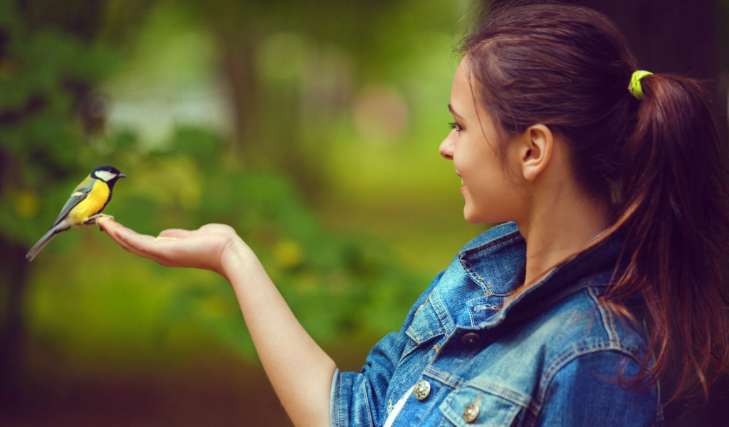 Синица сидит на руке у девушки