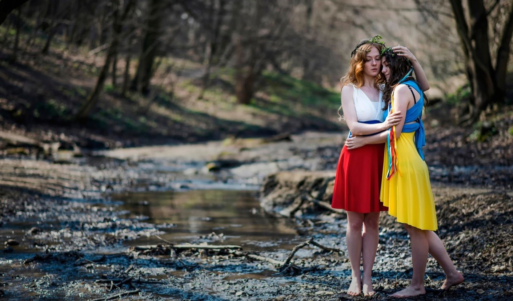 Две девушки в ярких платьях в чаще леса