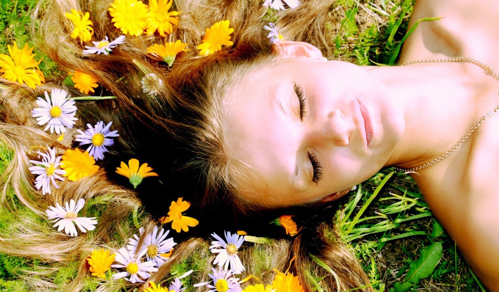 Белые и желтые цветы в волосах у девушки