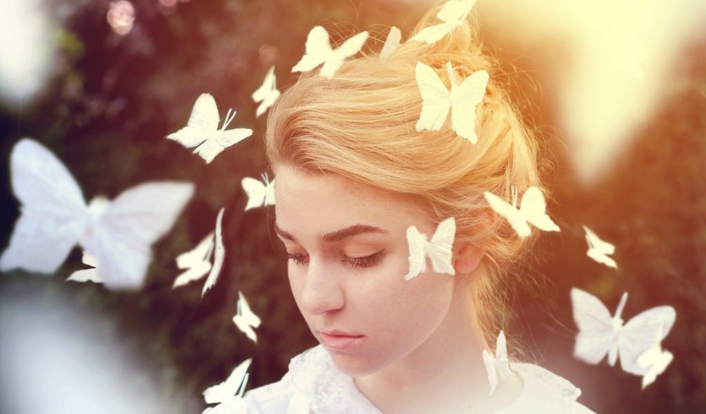 Белые бабочки летают вокруг девушки